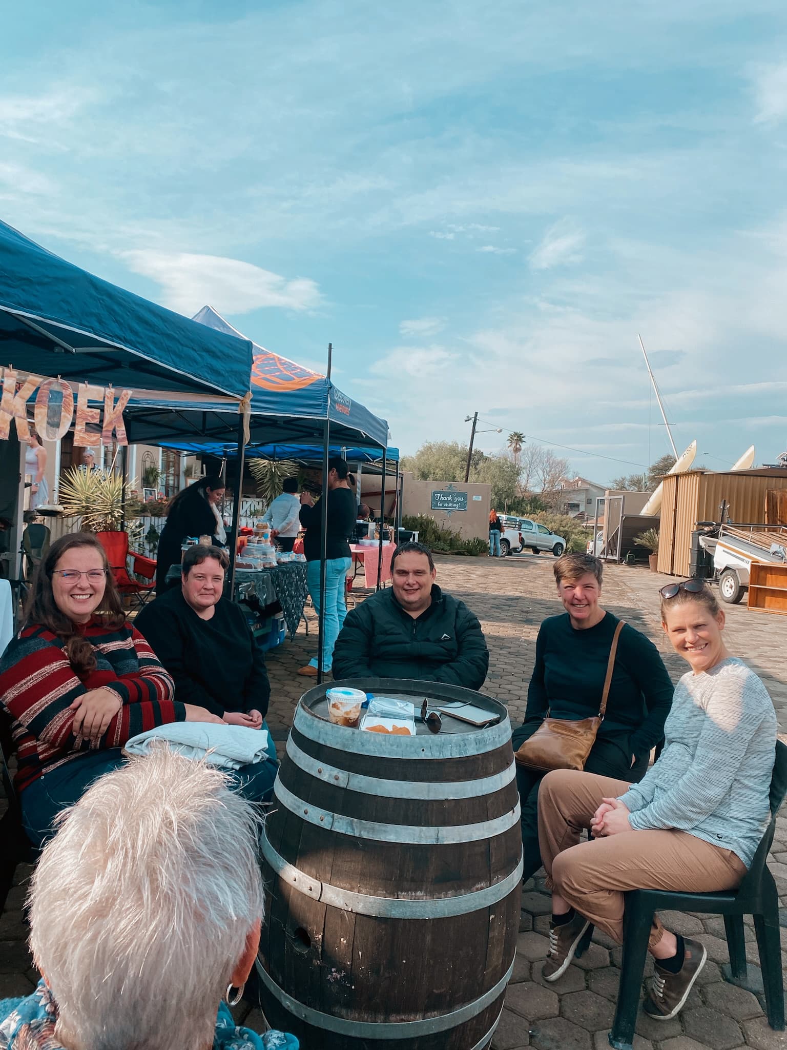 A group of visitors seated around a barrel table
